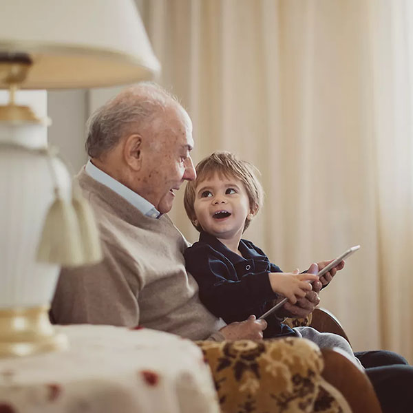 Older man with grandson on his lap talking about whole life insurance